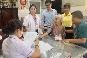 “Đội phản ứng nhanh” phường Minh Phụng (Thành phố Hồ Chí Minh) khám sức khỏe tại nhà cho bà Lê Thị Đời - 81 tuổi, đối tượng yếu thế. (Ảnh: MINH ANH)
