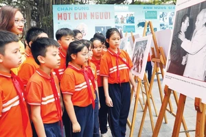 Học sinh tham quan triển lãm ảnh “Rạng rỡ tên Người” nhân dịp kỷ niệm 135 năm Ngày sinh Chủ tịch Hồ Chí Minh do Báo Nhân Dân tổ chức. (Ảnh: KHIẾU MINH)