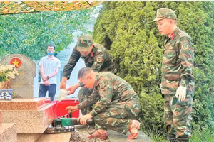 Cán bộ, chiến sĩ Bộ Chỉ huy quân sự tỉnh Điện Biên lấy mẫu trên từng phần mộ tại nghĩa trang liệt sĩ Him Lam.