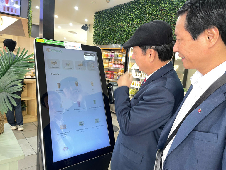 Đoàn cán bộ chương trình bồi dưỡng ngắn hạn tại Australia trải nghiệm thanh toán số tại một cửa hàng ở thủ đô Canberra (Australia)