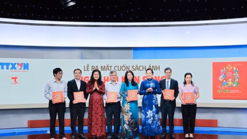 Phó Tổng Giám đốc Thông tấn xã Việt Nam Nguyễn Thị Sự tặng sách ảnh "Ngày hội non sông" cho các đại biểu.