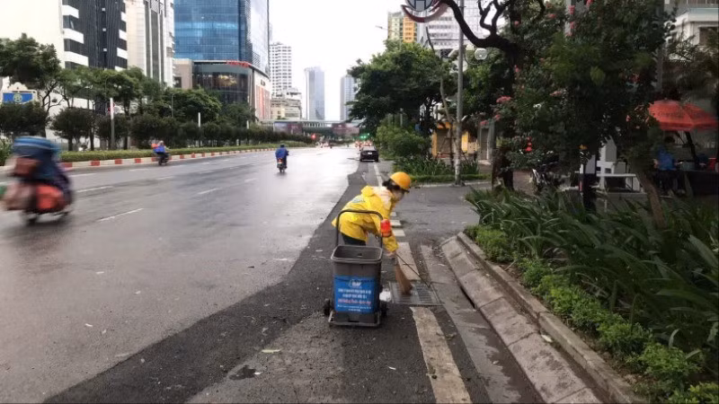 Công nhân Công ty Thoát nước Hà Nội vệ sinh các miệng thu nước trên đường Nguyễn Chí Thanh. (Ảnh: CẢNH HOÀNG)