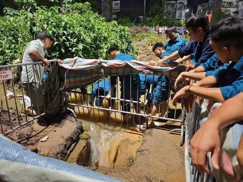 Lực lượng cứu hộ cứu nạn tìm thi thể nam sinh viên rơi xuống cống tử vong tại phường Đông Ngạc. (Ảnh: Đức Tuấn)
