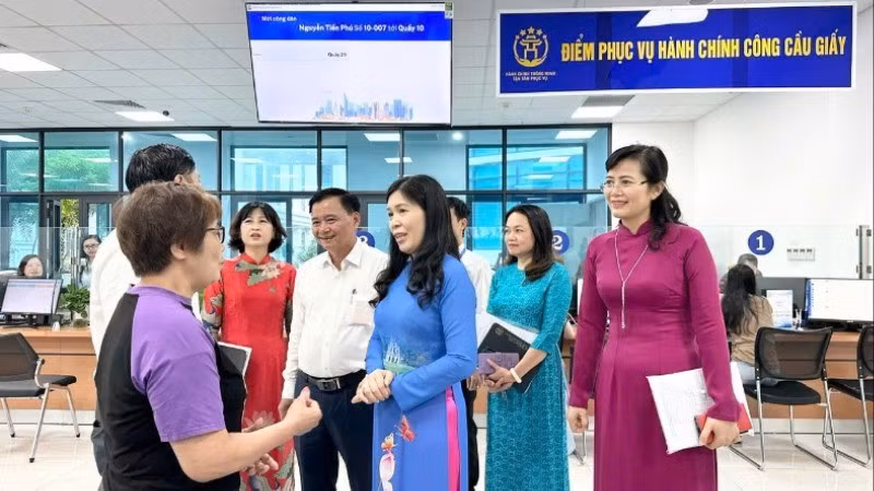 Lãnh đạo phường Cầu Giấy trò chuyện với người dân đến làm thủ tục hành chính. (Ảnh: HÀ PHONG)