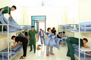 Cán bộ, chiến sĩ Đồn Biên phòng Chiềng On, Ban Chỉ huy Bộ đội Biên phòng tỉnh Sơn La phối hợp giáo viên chuẩn bị chỗ ngủ nghỉ cho các cháu học sinh nội trú. (Ảnh: QUÀNG HÙNG)