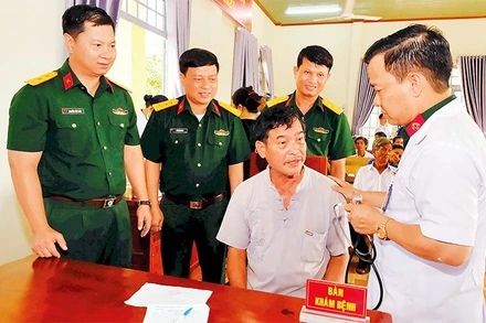 Lãnh đạo Trung đoàn 719 và bác sĩ Bệnh xá Quân dân y thăm hỏi và khám bệnh cho nhân dân.