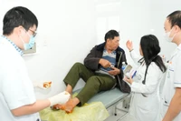 Các bác sĩ trong đoàn công tác trực tiếp xử trí một ca cấp cứu chấn thương bàn chân cho người.