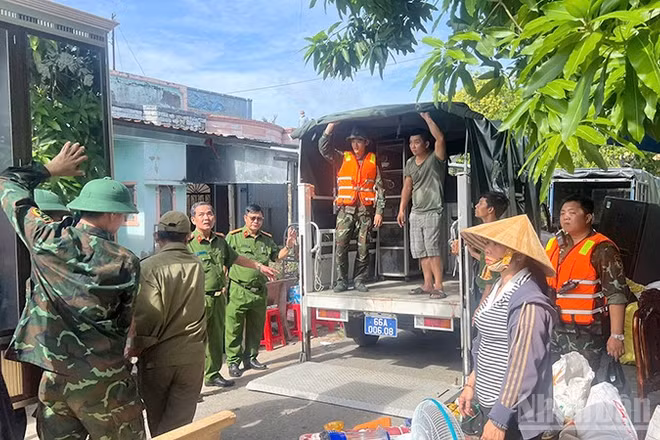 Lực lượng Công an, Quân sự giúp dân di dời tài sản ra khỏi khu sạt lở.