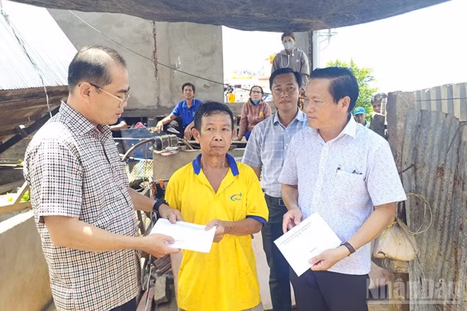 Trao tiền hỗ trợ hộ gia đình bị thiệt hại do thiên tai.