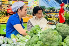 Người dân mua rau xanh bình ổn thị trường trong một siêu thị Co.opmart ở Thành phố.