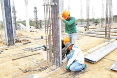 Các công nhân dựng trụ đổ bê-tông.