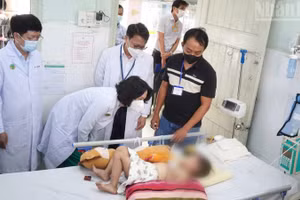 Đoàn công tác của Bộ Y tế thăm bệnh nhi điều trị tay chân miệng tại Bệnh viện Nhi đồng 2. (Ảnh: KHANG ANH)