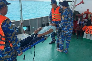 Đưa ngư dân bị nạn lên tàu.