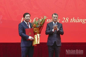 Đồng chí Lê Minh Hưng trao Quyết định và tặng hoa chúc mừng tân Bí thư Tỉnh ủy Lào Cai Dương Quốc Huy. (Ảnh: THANH SƠN)