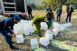 Tiêu hủy rượu không rõ nguồn gốc tại phường Nghĩa Lộ, tỉnh Lào Cai. (Ảnh: THANH SƠN)