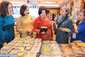 Chủ tịch Liên minh Hợp tác xã Việt Nam cùng các đại biểu tham quan gian hàng của các hợp tác xã bày bán tại Hội nghị.