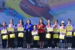 Bí thư Trung ương Đoàn, Chủ tịch Hội đồng Đội Trung ương Nguyễn Phạm Duy Trang (thứ 5 từ trái sang) cùng đại diện Ban tổ chức Ngày hội trao học bổng tặng thiếu nhi vượt khó học tốt.