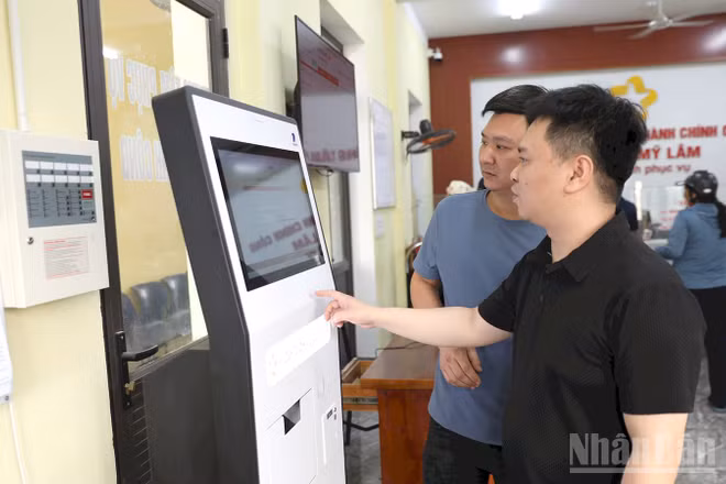 Người dân lấy số thứ tự thực hiện thủ tục hành chính tại ki-ốt tự động tại Trung tâm Hành chính công phường Mỹ Lâm. (Ảnh: Đức Thắng)