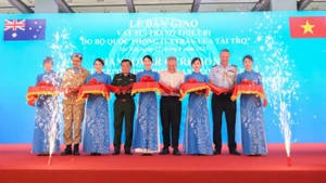 Thượng tướng Hoàng Xuân Chiến, Ủy viên Trung ương Đảng, Ủy viên Quân ủy Trung ương, Thứ trưởng Quốc phòng, Phó Tổng Thư ký Quốc phòng Australia Hugh Jeffrey cùng các đại biểu thực hiện nghi thức cắt băng lễ bàn giao vật tư, trang thiết bị.