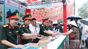 Thiếu tướng Nguyễn Trọng Thiện, Phó Chủ nhiệm Tổng cục Hậu cần-Kỹ thuật phát lương khô, nước uống do Công ty Cổ phần 22 sản xuất cho bà con tại Vườn hoa Lý Tự Trọng.