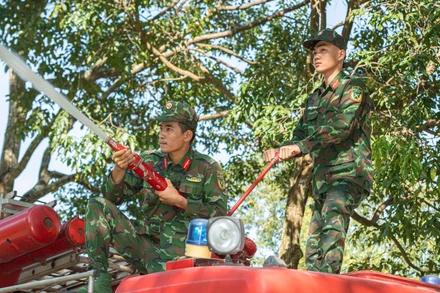 Chiến sĩ phối hợp điều khiển vòi cứu hỏa, yêu cầu một người giữ chắc đầu vòi hướng thẳng vào đám cháy, người còn lại giữ thân vòi tạo lực ổn định.