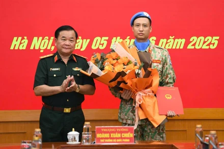 Thượng tướng Hoàng Xuân Chiến tặng hoa chúc mừng, động viên Thiếu tá Trần Viết Cường lên đường làm nhiệm vụ.