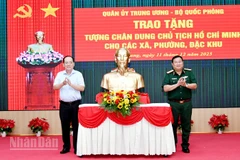 Thiếu tướng Nguyễn Văn Tiền, Phó Tư lệnh Quân khu 9 và Phó Chủ tịch Ủy ban nhân dân tỉnh An Giang Nguyễn Thanh Phong thực hiện nghi thức trao tặng tượng Bác Hồ. (Ảnh: PHƯƠNG VŨ).