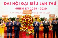 Thay mặt Bộ Chính trị, Đại tướng Phan Văn Giang tặng hoa của Ban Chấp hành Trung ương cho Đảng bộ tỉnh An Giang. (Ảnh: Ban tổ chức Đại hội cung cấp)