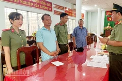Điều tra viên tống đạt các quyết định khởi tố vụ án, khởi tố bị can, thực hiện lệnh bắt bị can để tạm giam đối với Trần Văn Tiếng (thứ 2, từ trái qua).