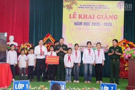 Đại tá Đào Quốc Thạo, Phó Bí thư Đảng ủy, Chỉ huy trưởng Bộ đội Biên phòng Lạng Sơn (đứng giữa) trao các phần hỗ trợ cho 10 em học sinh tại Trường Mầm non, Tiểu học và Trung học cơ sở Tam Gia, xã Khuất Xá, tỉnh Lạng Sơn.