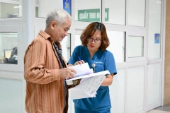 Bác sĩ Bệnh viện Thanh Nhàn, Hà Nội hướng dẫn bệnh nhân đến các phòng chuyên môn. (Ảnh THẾ ĐẠI)