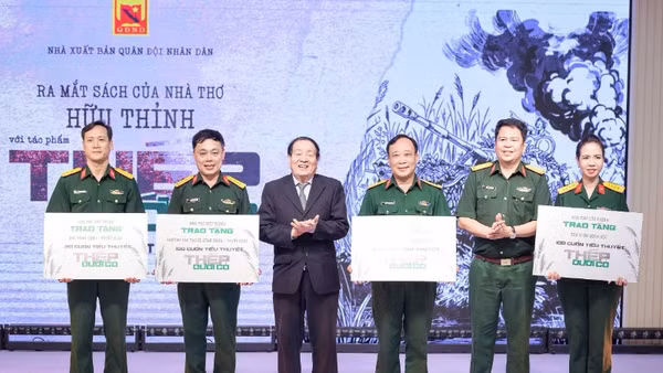 Nhà thơ Hữu Thỉnh và đại diện Nhà xuất bản Quân đội nhân dân tặng sách cho các đơn vị trong quân đội.