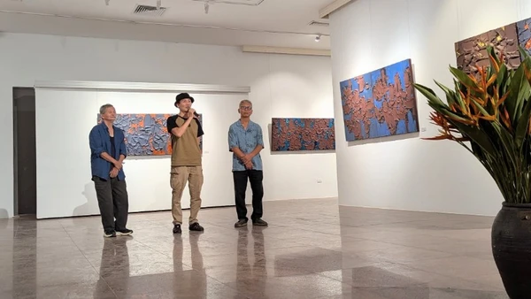 Họa sĩ Trần Lê Nam (bên phải) tại lễ khai mạc triển lãm.