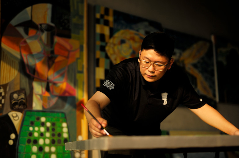 Họa sĩ Vũ Tuấn Việt đang hoàn thành sáng tác trong chủ đề "Hiện thực song song".