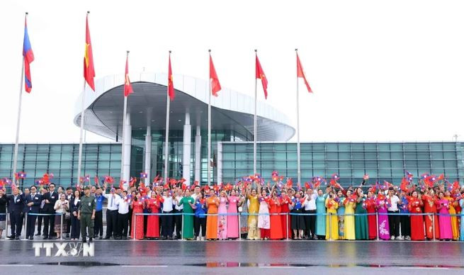 Đông đảo nhân dân Thủ đô Hà Nội cùng cán bộ, nhân viên Đại sứ quán và lưu học sinh Lào ra sân bay quốc tế Nội Bài chào đón Tổng Bí thư, Chủ tịch nước Lào Thongloun Sisoulith cùng Phu nhân và Đoàn đại biểu cấp cao Đảng, Nhà nước Lào thăm cấp Nhà nước tới Việt Nam. (Ảnh: Phạm Kiên/TTXVN)