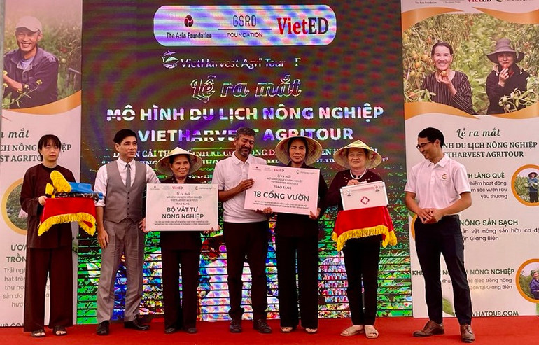 Đại diện dự án trao tặng vật tư nông nghiệp cho đại diện các hộ nông dân.