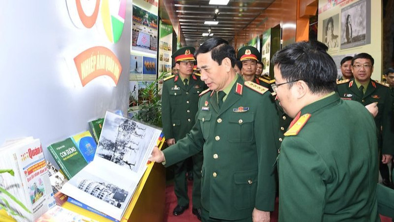 Đại tướng Phan Văn Giang và các đại biểu tham quan gian trưng bày về nhiếp ảnh quân đội. (Ảnh: QĐND)