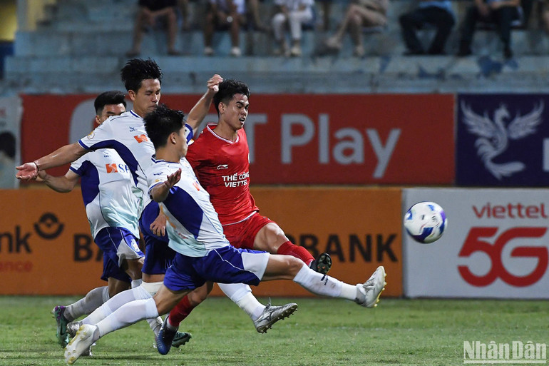 Khuất Văn Khang trước sự truy đuổi của các cầu thủ Đà Nẵng. (Ảnh: TRẦN HẢI)
