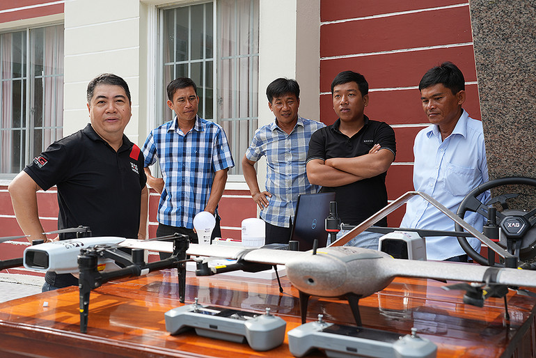 Bà con nông dân, thanh niên vùng nông thôn Đồng Tháp tham quan, tìm hiểu thiết bị nông nghiệp hiện đại qua sự hướng dẫn của đại diện XAG Mekong bên lề lễ ký kết.