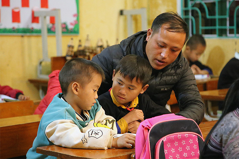 Thầy giáo Sùng A Trừ và học trò Trường Phổ thông dân tộc bán trú Tiểu học và Trung học cơ sở Chế Tạo (xã Chế Tạo, huyện Mù Cang Chải, tỉnh Yên Bái) trong buổi học nơi rẻo cao.