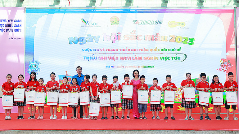 Đồng chí Lê Anh Quân (áo xanh) cùng đại diện Ban tổ chức Ngày hội trao quà tặng thiếu nhi.