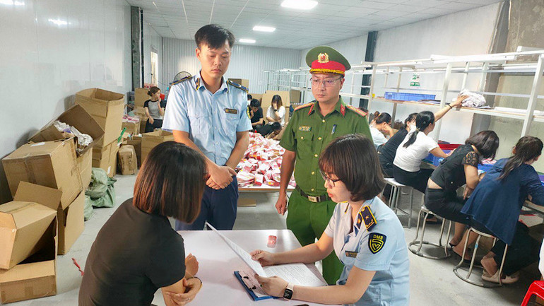 Lực lượng Quản lý thị trường phối hợp với lực lượng Công an kiểm tra một kho hàng vi phạm