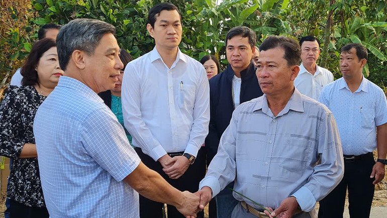 Đồng chí Đồng Văn Thanh (bên trái) chúc Tết, động viên đại diện Hợp tác xã Nông nghiệp Phước Lộc.