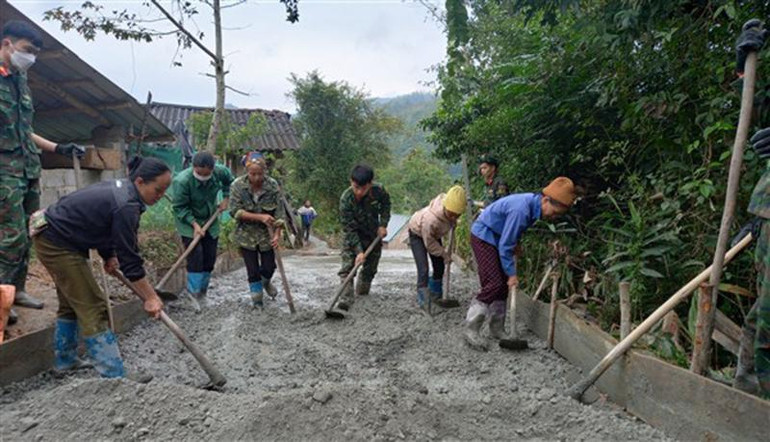 Bộ đội và người dân cùng làm đường bê-tông.