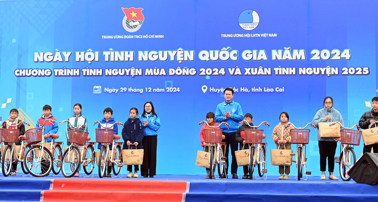 Phó Chủ tịch Thường trực Hội Liên hiệp Thanh niên Việt Nam (hàng sau, bên phải) và đại diện tổ chức Đoàn, Hội địa phương trao xe đạp tặng học sinh vượt khó học tốt.