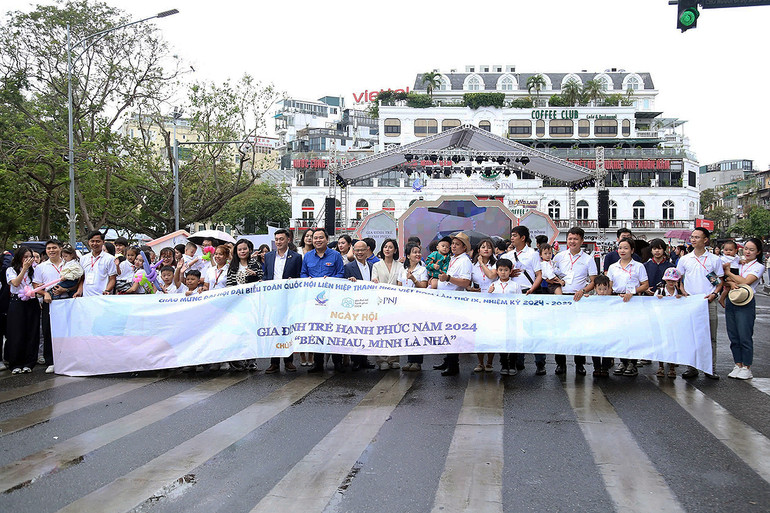 Các "Gia đình trẻ hạnh phúc" năm 2024 cùng đại biểu Ngày hội đi bộ tuyên truyền gắn kết gia đình tại quảng trường Đông Kinh Nghĩa Thục.