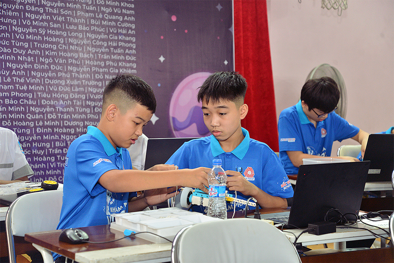 Các "kỹ sư nhí" lắp ráp, chuẩn bị robot trước giờ thi đấu.
