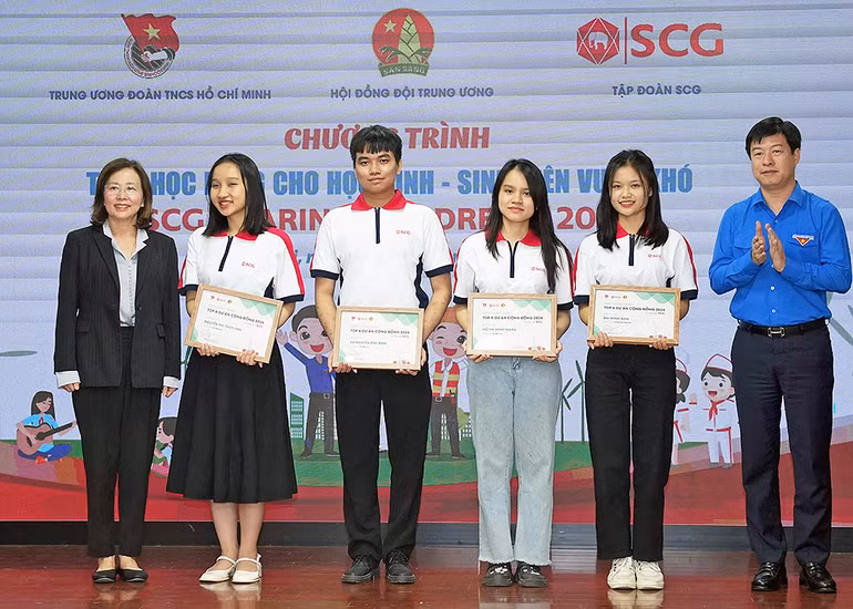 Phó Chủ tịch Thường trực Hội đồng Đội Trung ương Lê Hải Long (ngoài cùng bên phải) và đại diện các đơn vị liên quan trao học bổng tặng sinh viên vượt khó học tốt.