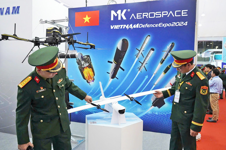 Khách tham quan đang tìm hiểu thiết bị UAV có khả năng thực hiện các nhiệm vụ trinh sát, tấn công chiến thuật hoặc ứng dụng trong các hoạt động dân sự tại Triển lãm Quốc phòng quốc tế Việt Nam 2024.