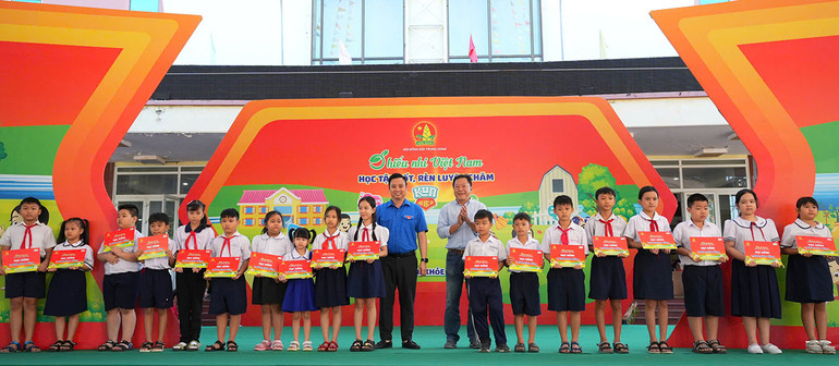 Đồng chí Lê Anh Quân (áo xanh) cùng đại diện lãnh đạo địa phương trao học bổng "Tiếp sức cho em đến trường" tặng thiếu nhi vượt khó học tốt.